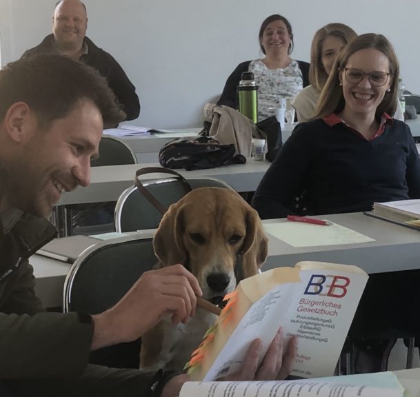 Mann und Hund gucken gemeinsam in ein Buch